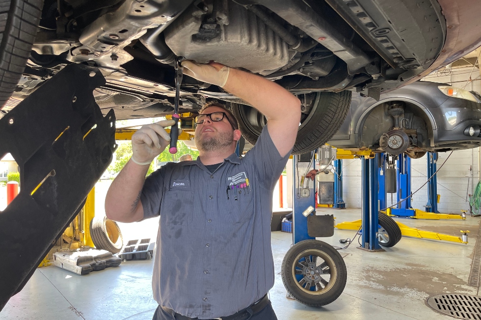 Richmond Street Automotive technician inspecting the underside of a vehicle during auto repair service in Appleton, WI